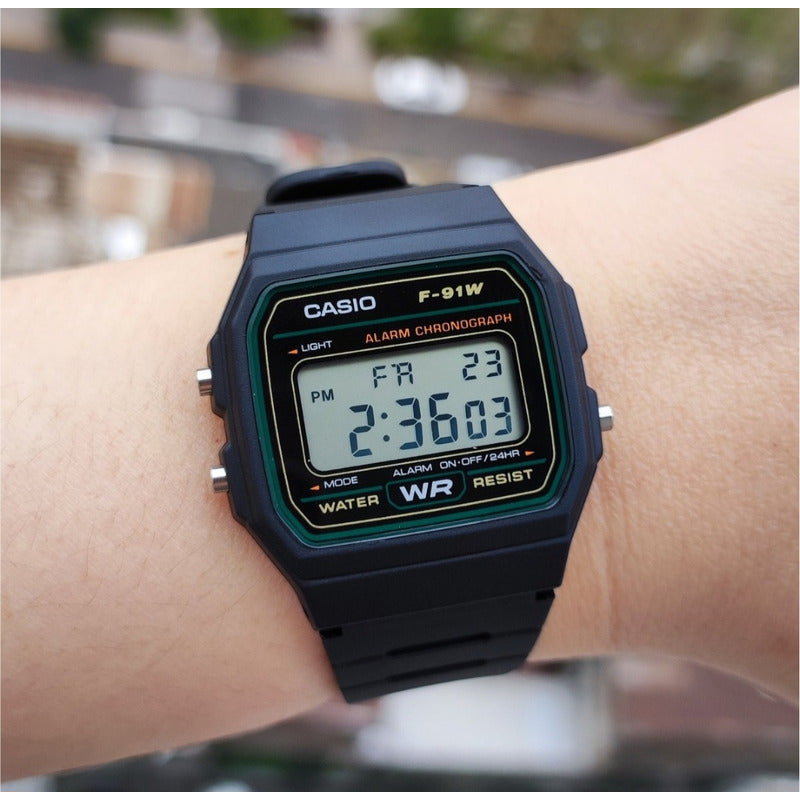 Reloj De Pulsera Casio Collection F-91w-3dg De Cuerpo Color Negro, Digital, Para Hombre, Fondo Gris, Con Correa De Resina Color Negro, Dial Negro, Bisel Color Verde Y Hebilla Sim